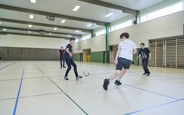 Kickende Jugendliche in Sporthalle auf noraplan sentica Sporthallenboden
