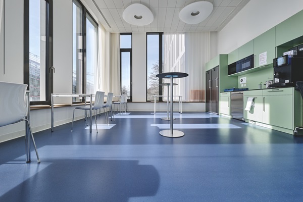 Pausen-/Aufenthaltsraum im Spital mit Küchenzeile, Bistrotischen und Sitzplätzen