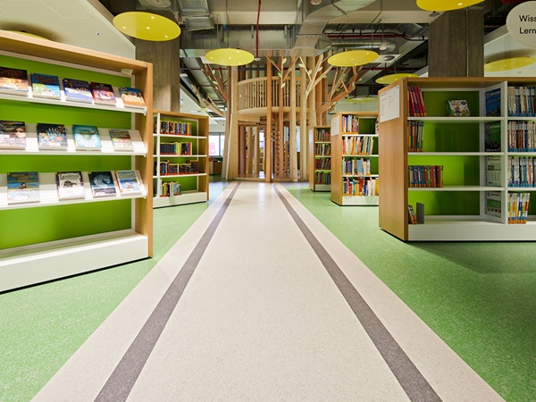Farbige Streifen im Bodenbelag imitieren eine Eisenbahnstrecke und führen durch eine Bibliothek